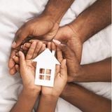 Set of African American hands holding a cutout of a house