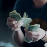 Young woman counting dollar bills